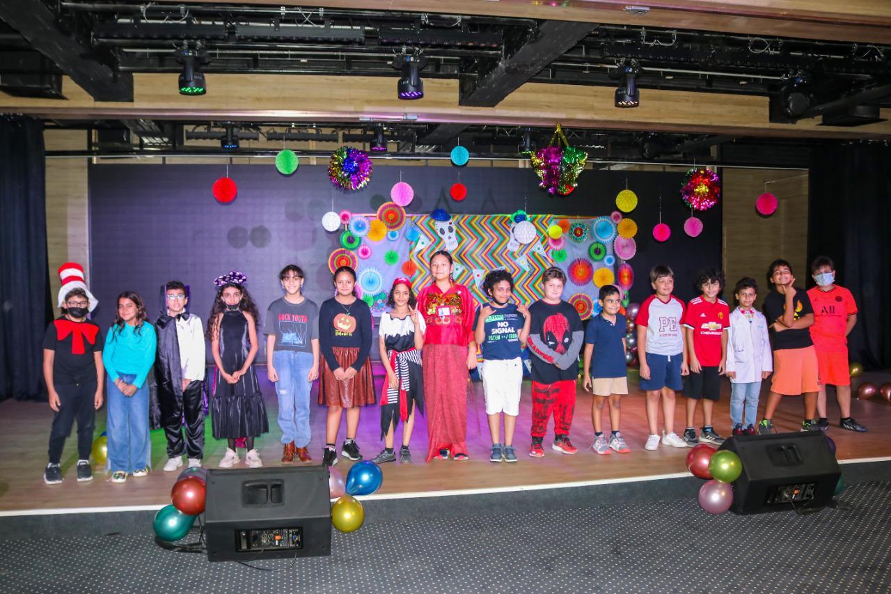 Group of children from IVY STEM International School performing on a decorated stage with various costumes and vibrant atmosphere.